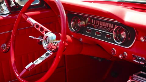 Close-up of the bright red interior dashboard and steering wheel of a classic Stock Footage 341784617