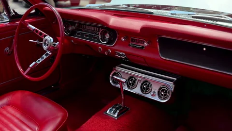 Close-up of the bright red interior dashboard and steering wheel of a classic Stock Footage 341784644
