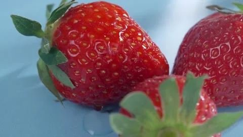 Close-up of bright strawberries on a yellow background with water dripping on 스톡 동영상 274814784