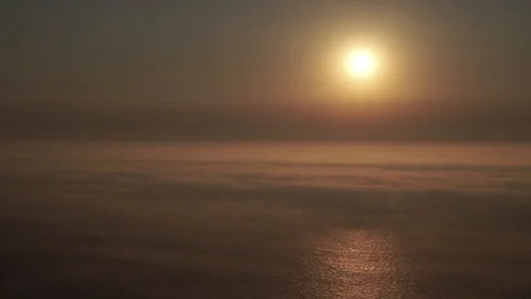 Close up on bright sun shining bright above cloudy ocean horizon near sunset Stock Footage 88002584