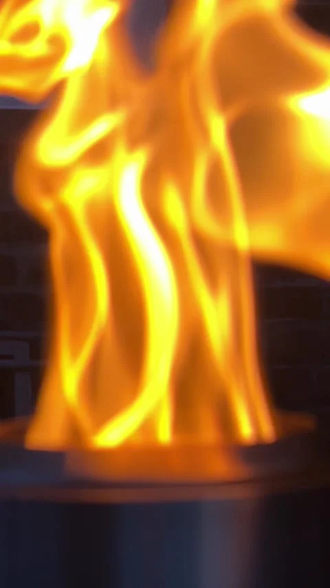 Close-up of a bright tabletop fire pit flame creating a warm outdoor atmosphere Stock Footage 340562780