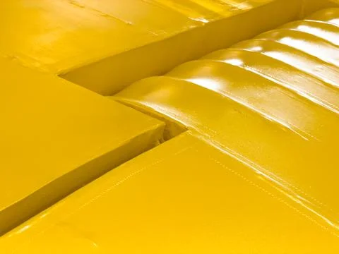Close-up of a bright yellow painted plane wing with small highlights Stock Photos