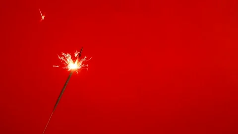 Close up of Brightly burning sparkler on a red background Stock Footage 165767130