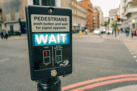 Close-up of a British pedestrian crossing push-button with illuminated WAIT.. Stockfoto's