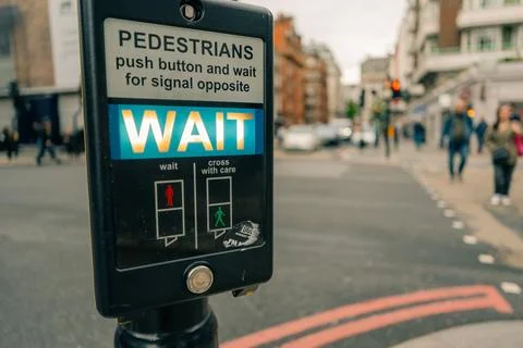 Close-up of a British pedestrian crossing push-button with illuminated WAIT.. Stock Photos
