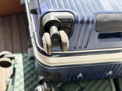 Close up of broken double spinner wheel on a blue hard shell luggage suitcase. Stock Photos