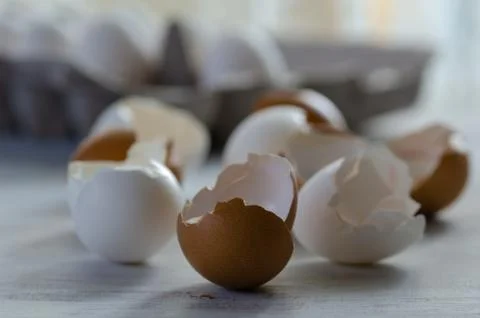 Close up of broken egg shells on wooden background. Stock Photos