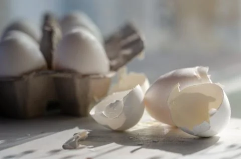 Close up of broken egg shells on wooden background. Stock Photos
