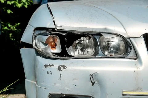 Close-up of a broken headlight on a gray car on a sunny day. Crash concept Stock Photos