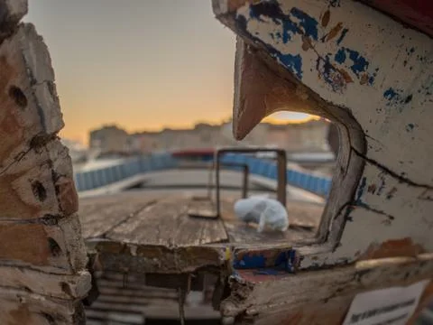 A close up of the broken hull of a boat, in the background one can observe th Stock Photos
