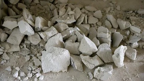 Close up of broken plaster and concrete debris on a dusty floor during Stock Photos