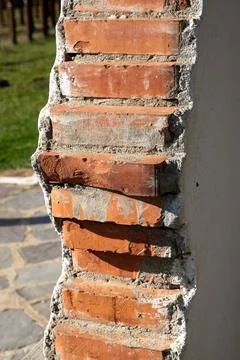 Close up of a broken red brick wall on a sunny day Fotos de archivo
