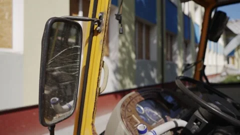 Close-up of a broken side mirror on a yellow bus involved in an accident Stock Footage 344647315