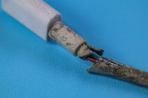 Close up Broken Smart Phone Charger Cable on blue background Stock Photos