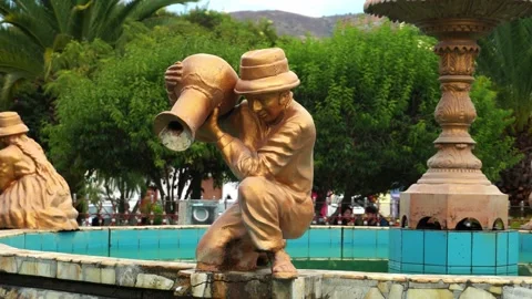 Close-up of a bronze and gold-colored sculpture of a compesino man with a vase Video stock 164469837