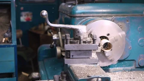 Close up of bronze bushing on old shabby blue lathe, metal shavings flying. Video stock 81558534