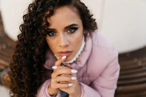 Close-up. the brooding face of a curly brunette with beautiful full lips and Stock Photos