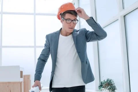 Close up. the brooding young architect adjusted his helme Stock Photos