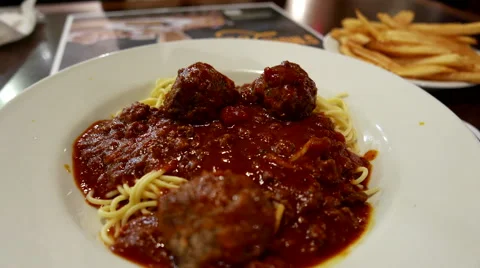 Close up brooklyn spaghetti meatballs and fries on table Stock Footage 67824479