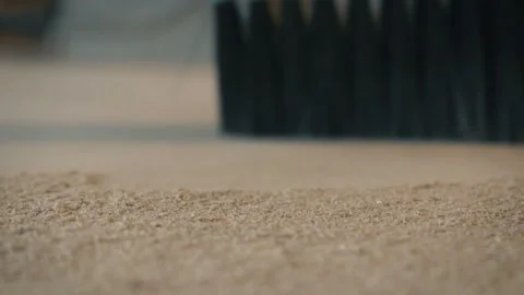 Close up of broom cleaning and blows away dust from wooden carpenter workbench Stockbeeldmateriaal 103619296