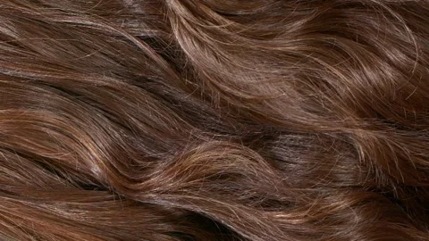 Close-up brown curly hair texture, female long hair background in slow motion 動画素材 285016874