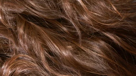 Close-up brown curly hair texture, female long hair background in slow motion Stock Footage 313174875