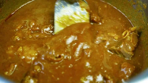 Close-up of brown curry stew with spoon, Close-up view of rich brown curry .. Video stock 346467089