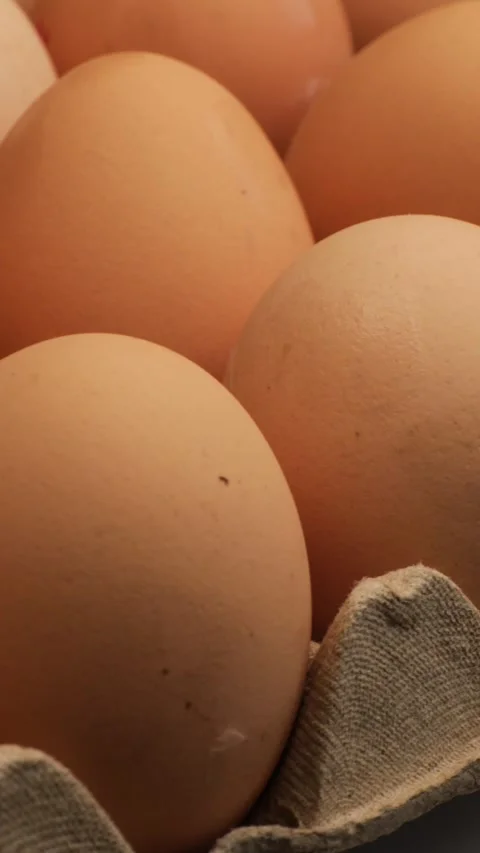 Close-up brown eggs in recyclable tray, rotation in circle. healthy organic food Stock Footage 323331720