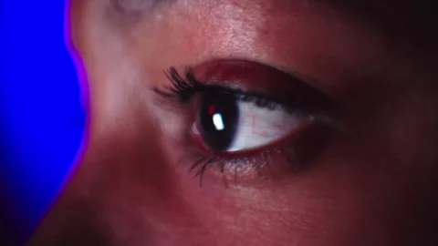 Close-up of brown eye of unrecognizable young black girl looking at screen Stock Footage 252070800