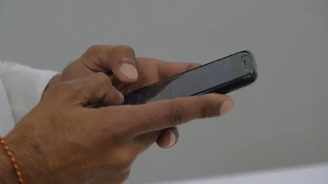 Close up of brown hands typing on a touch screen mobile phone smart device  Stock Footage 100054966