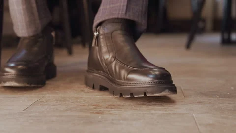 Close up of brown leather ankle boot with zip side and chunky sole on tiled Stock-Footage 345738457