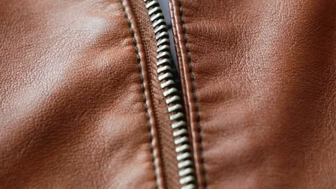 Close up of brown leather jackets with a zipper on it. 4k pan shot Video stock 77506765