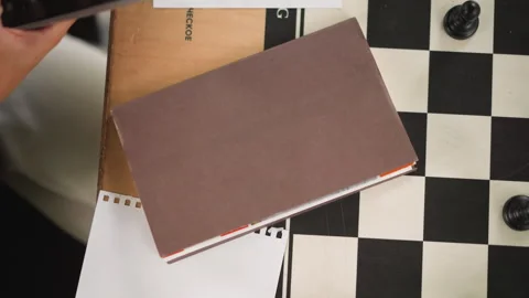 Close up of brown notebook with chess piece wooden board paper in soft indoor Stock-Footage 346650078