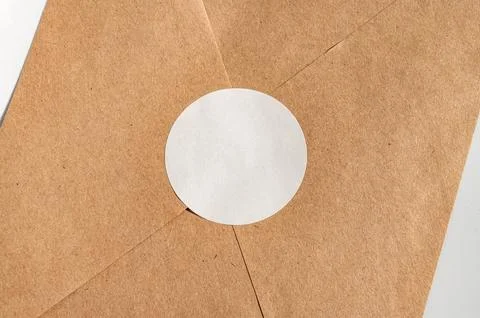 Close-up of brown paper envelope with white circle seal Fotos de archivo