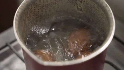 Close-up of brown shell eggs boiling. Hot water with bubbles, high-protein food 스톡 동영상 345154785