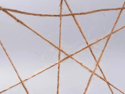 Close-up of brown twine strings crossing on gray background Photos