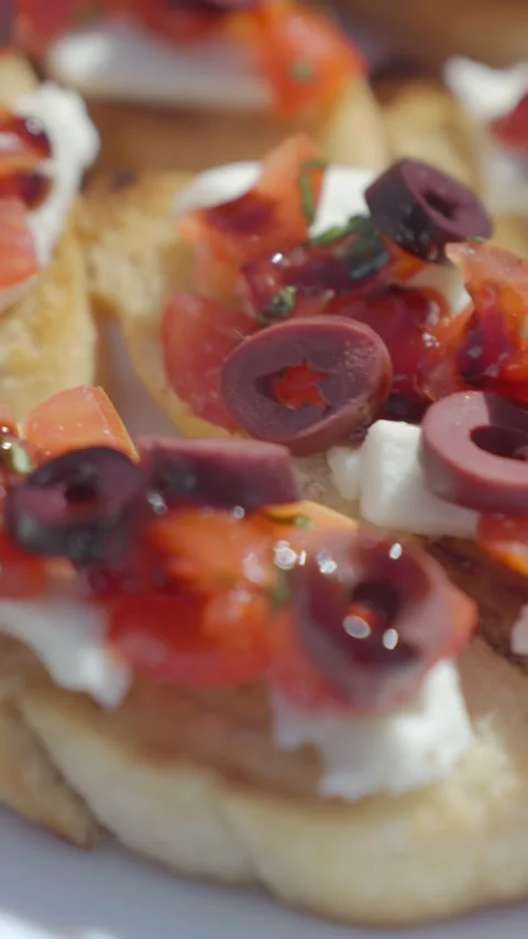 Close up of bruschetta with tomato, mozzarella and olives on toasted bread Stock Footage 336632241