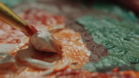 Close-Up of Brush Blending White and Orange Paint Colors on Palette Stock Footage 300342160