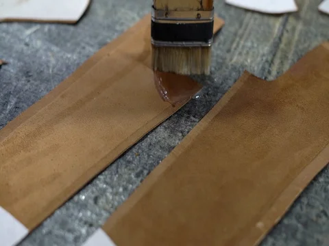 Close-Up Brush Puts Glue on The Edges of The Inner Surface of the Leather Stock Footage 76121540