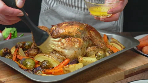 Close-up of brushing and marinating with sauce a whole chicken after grilling. Stock Footage 145117543