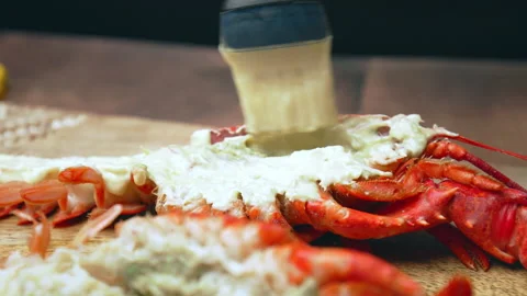 Close-up of brushing half cutted red lobster with melted butter and sauce in 4K. Video stock 146342906