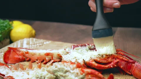 Close-up of brushing half cutted red lobster with melted butter and sauce in 4K. Stock Footage 146343087