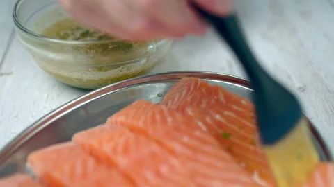 Close-up of brushing raw salmon with marinade sauce using a basting brush. Stock Footage 132822265