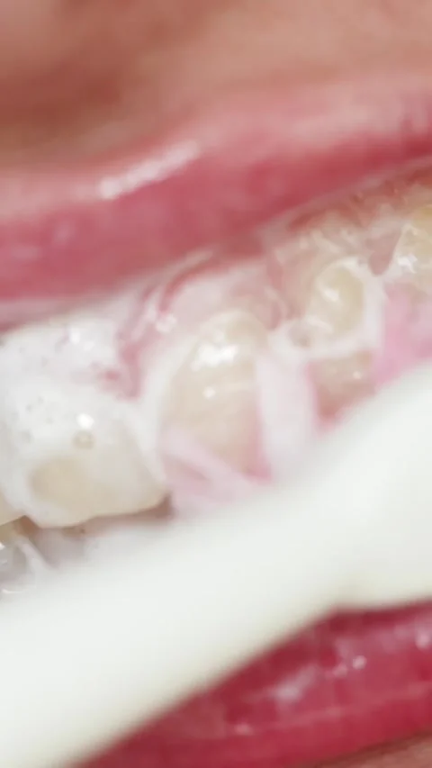 Close-up of brushing teeth with foam and toothbrush, oral hygiene routine Video stock 343838151