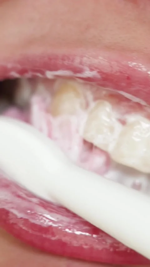 Close-up of brushing teeth with foam and toothbrush, oral hygiene routine Stockbeeldmateriaal 343838153