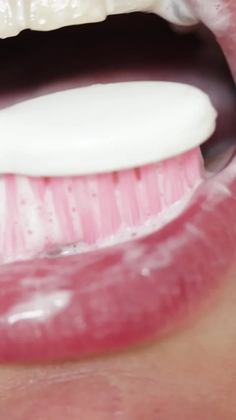 Close-up of brushing teeth with a white tablet and pink toothbrush Vidéo 343838163