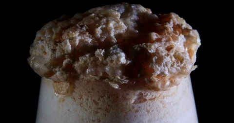 Close up of bubbles and growing foam overfilling a glass from a magic potion Stock Footage 107848845