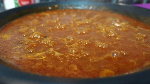 Close up of bubbles from boiling paella while it is cooking Stock Footage 163925957