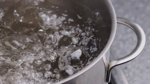 Close up of bubbles in boiling water. Fragment of pot with boiling water Stock Footage 154473835