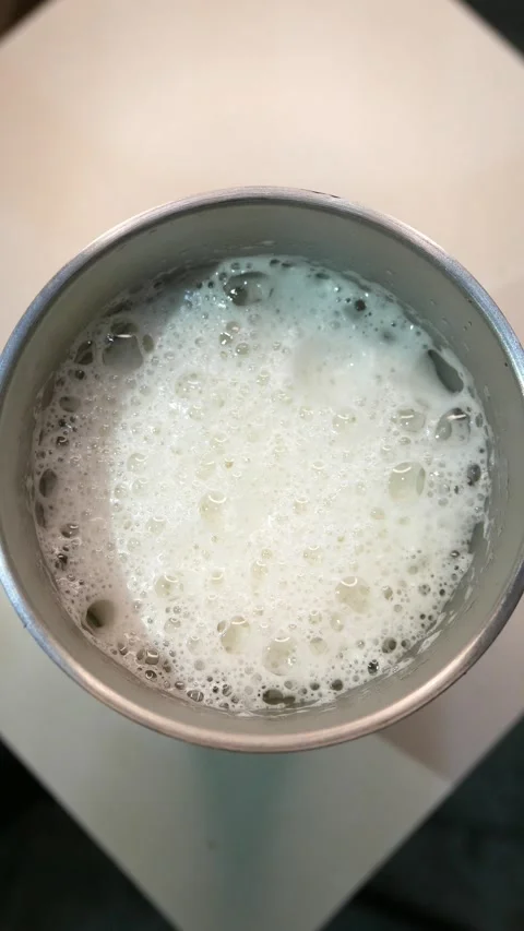 A close-up of bubbles bursting in beer foam. A glass of beer on the table Stock Footage 331969698